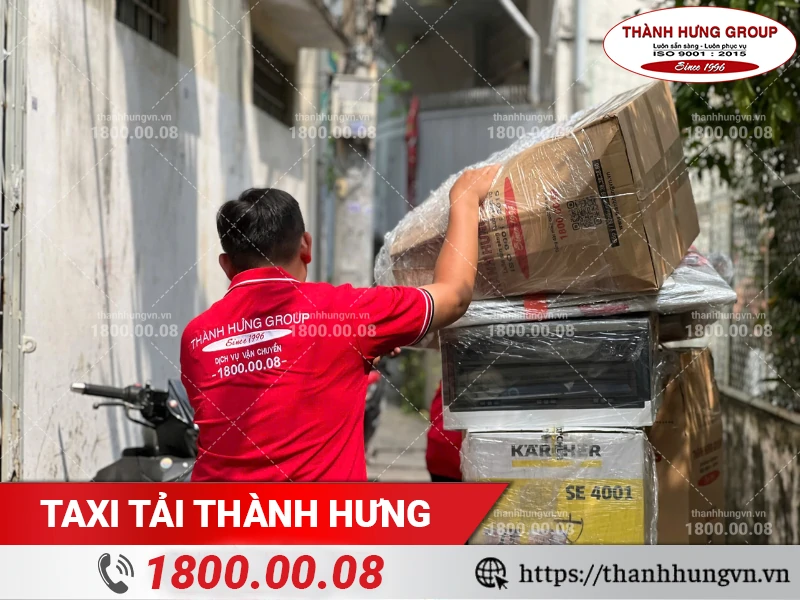 Nhân viên Thành Hưng vận chuyển đồ từ hẻm ra xe tải bằng xe đẩy chuyên dụng